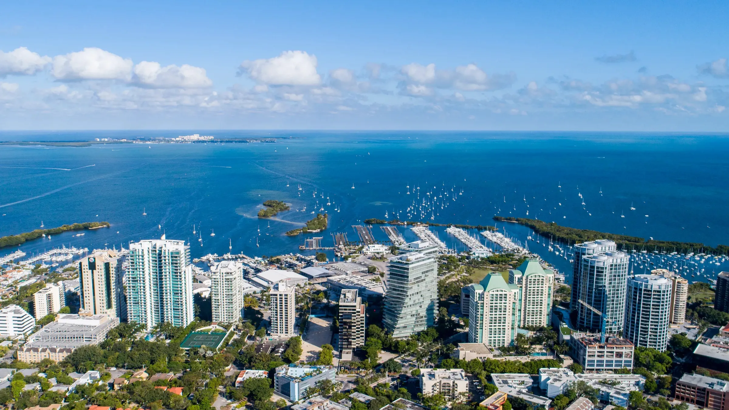 Aerial view of Miami waterfront towers, a marina and the bay